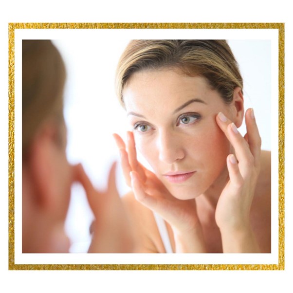 Woman looking her face at a mirror